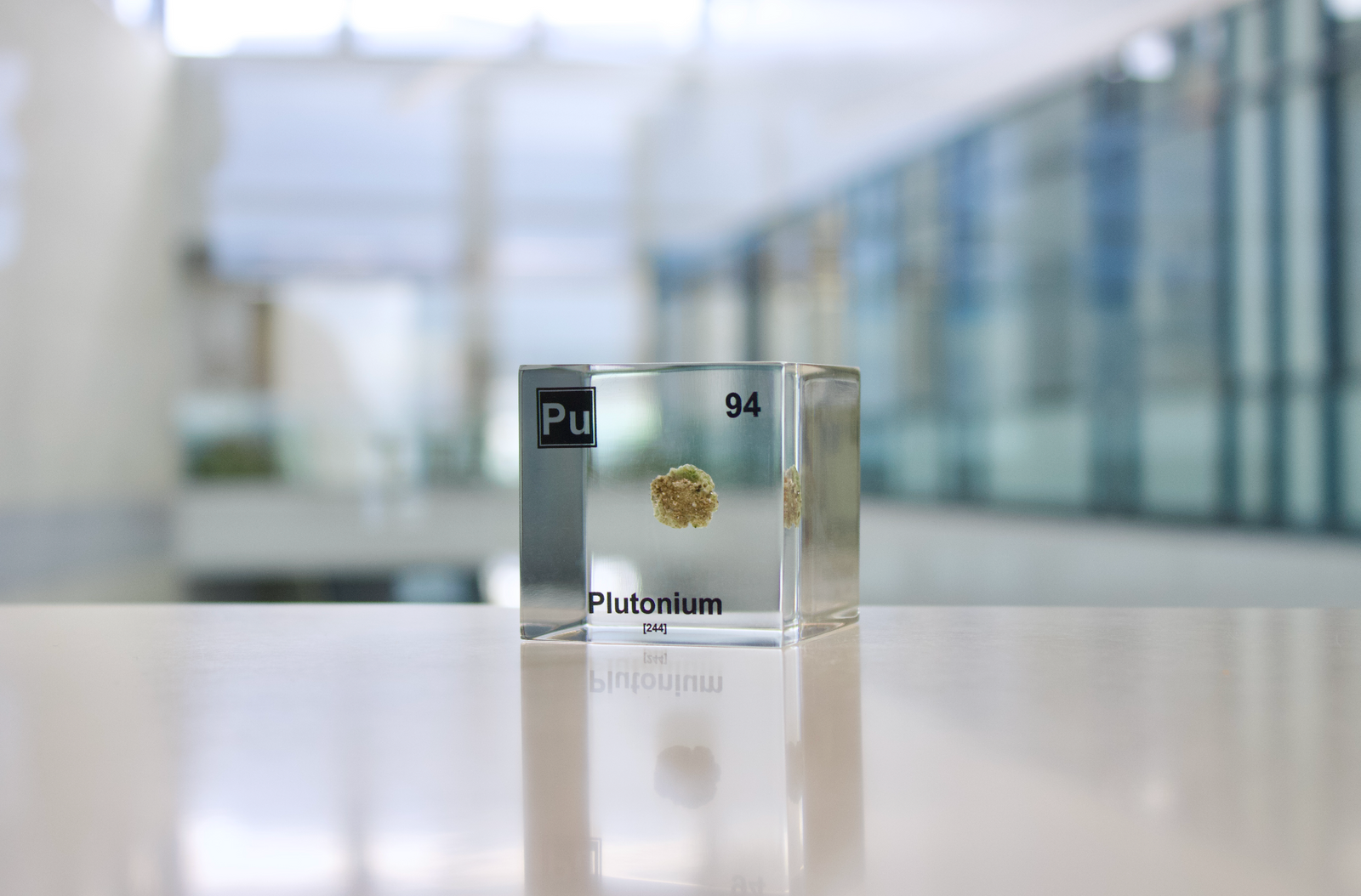 Plutonium element cube front view on white background, rare radioactive element collector gift