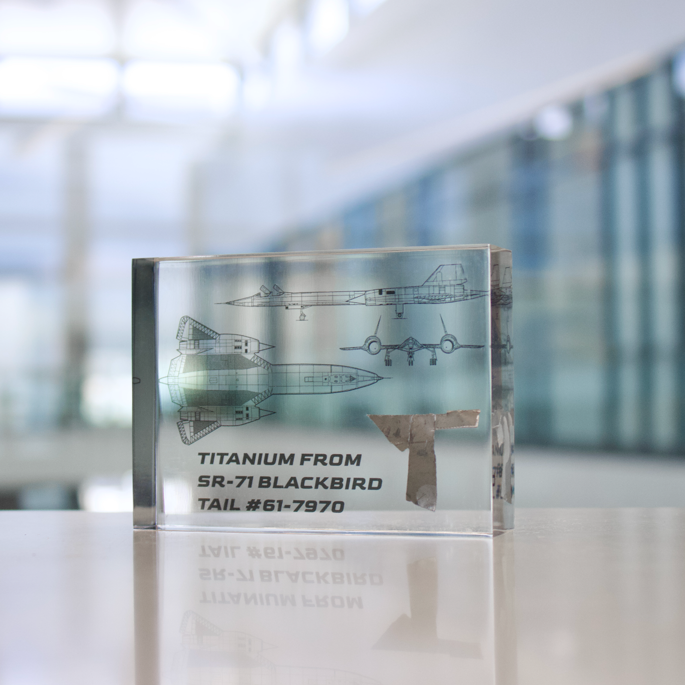 SR-71 Blackbird titanium aircraft metal piece displayed on moon gray background, collector gift for aviation fans