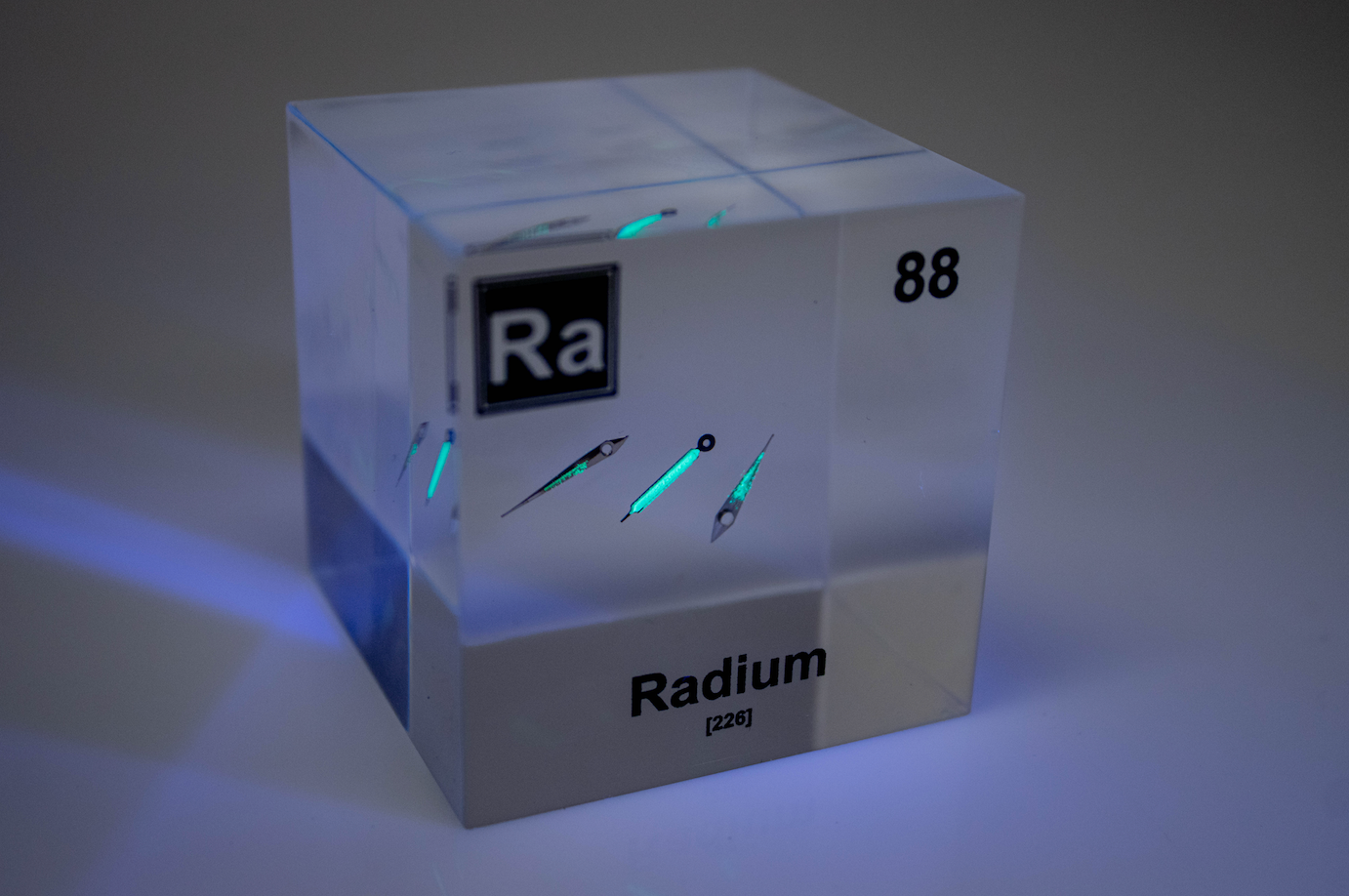Radium element cube front view on white background, rare radioactive chemistry collector gift
