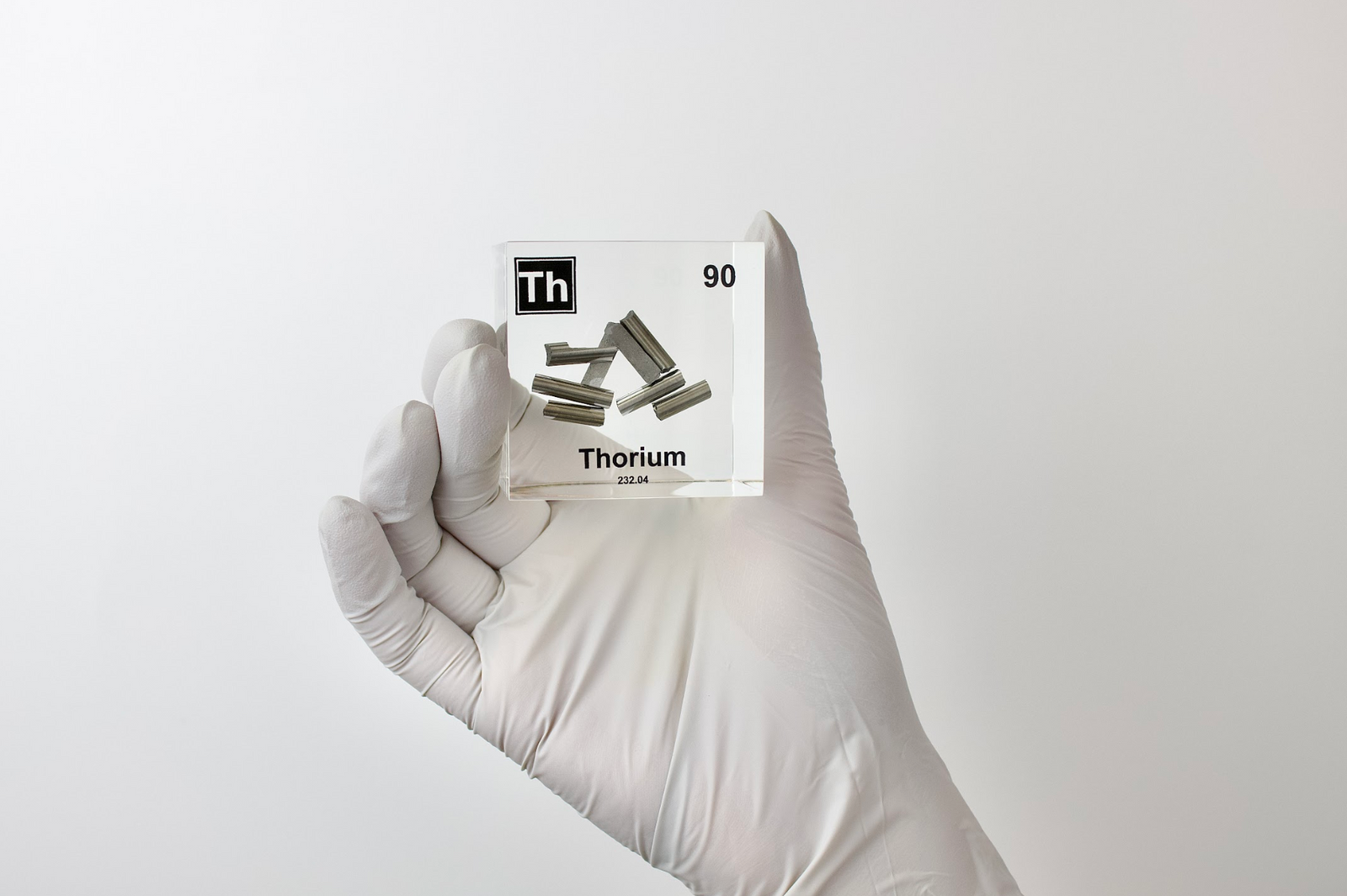Thorium element cube front view on white background, rare radioactive collector gift for science fans