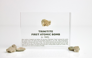 Trinitite fragment displayed beside its acrylic case on white background, unique collector gift