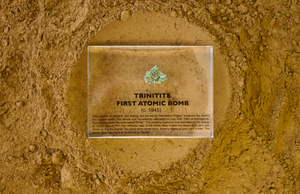 Trinitite specimen from the first atomic bomb test facing up on a textured background, collector gift