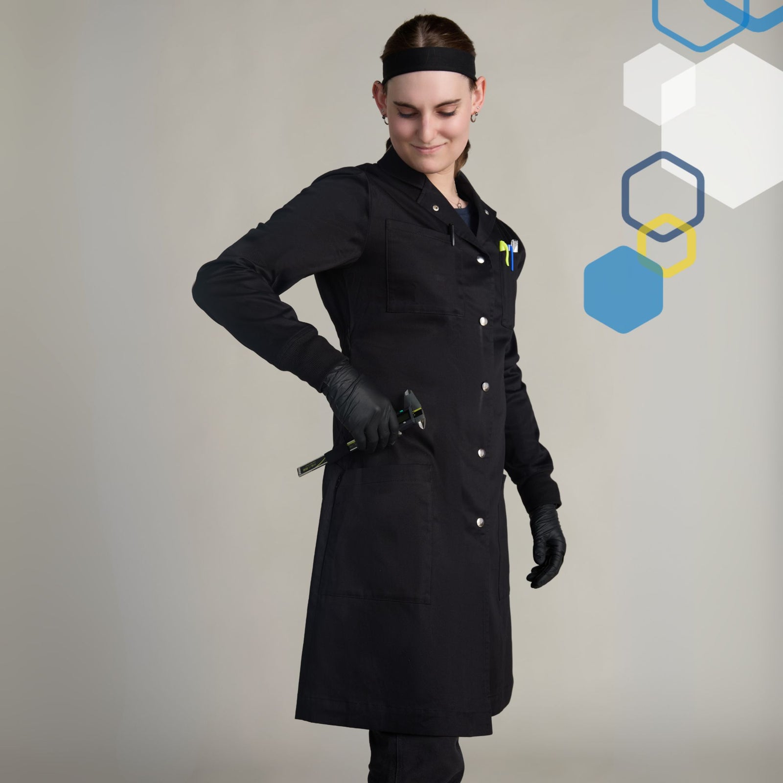 Female engineer wearing a small black 100 percent cotton scientist lab coat wearing black gloves using pockets and