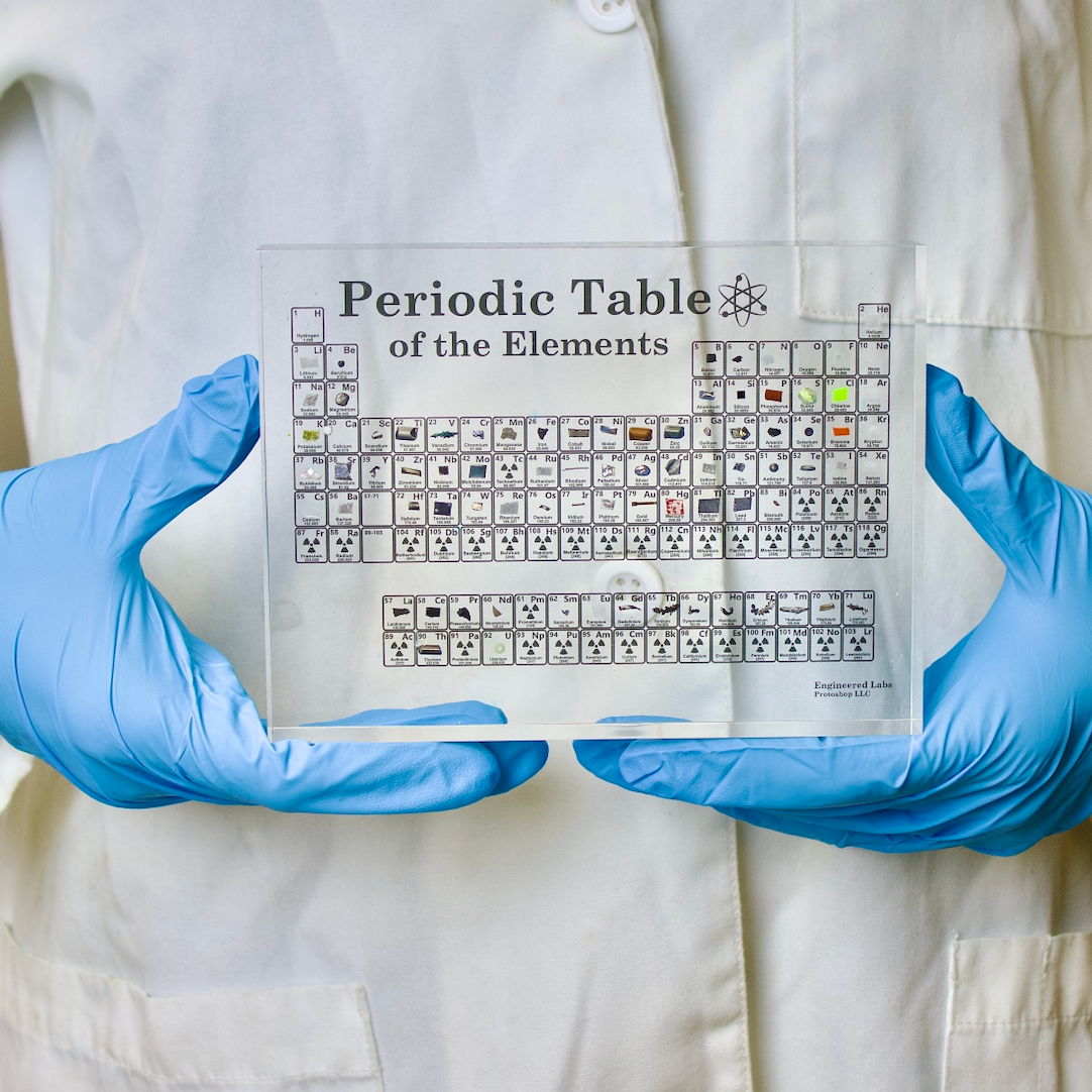 Heritage periodic table display close-up showing real element samples inside acrylic, collector gift