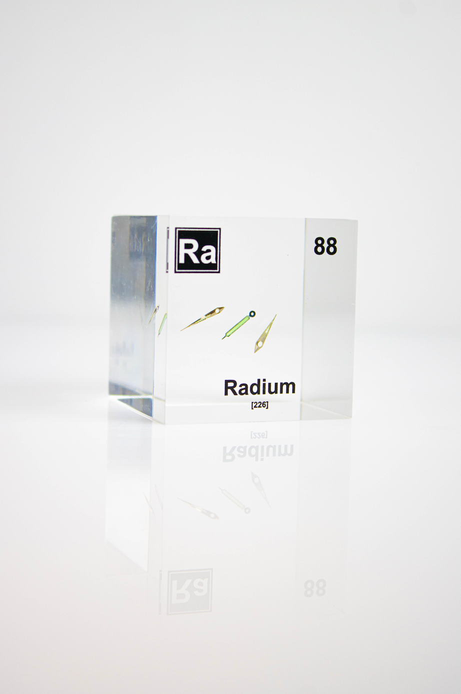 Radium element cube with dimension measurements on white background, collector gift