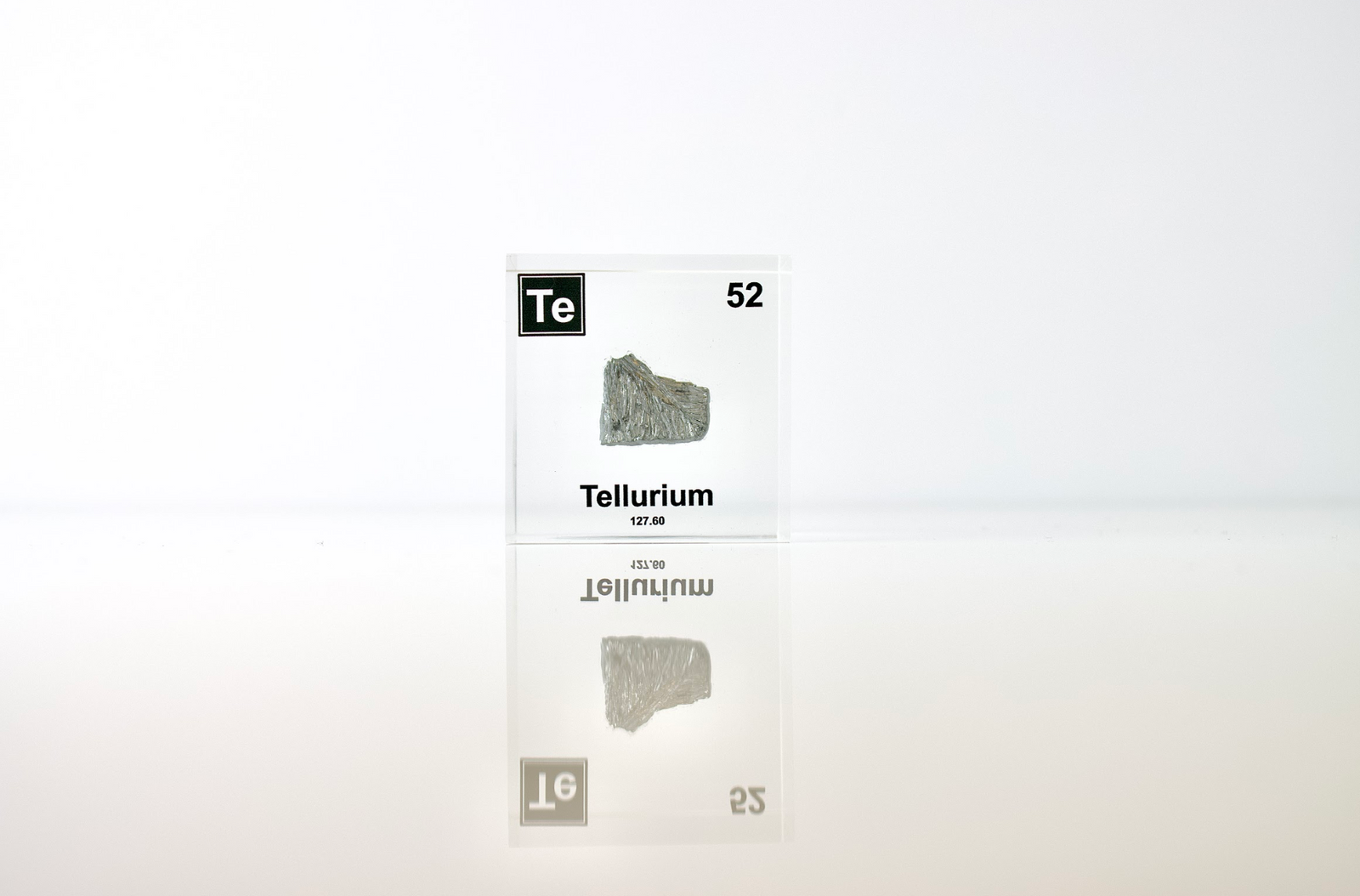 Tellurium element cube with dimension measurements on white background, collector gift