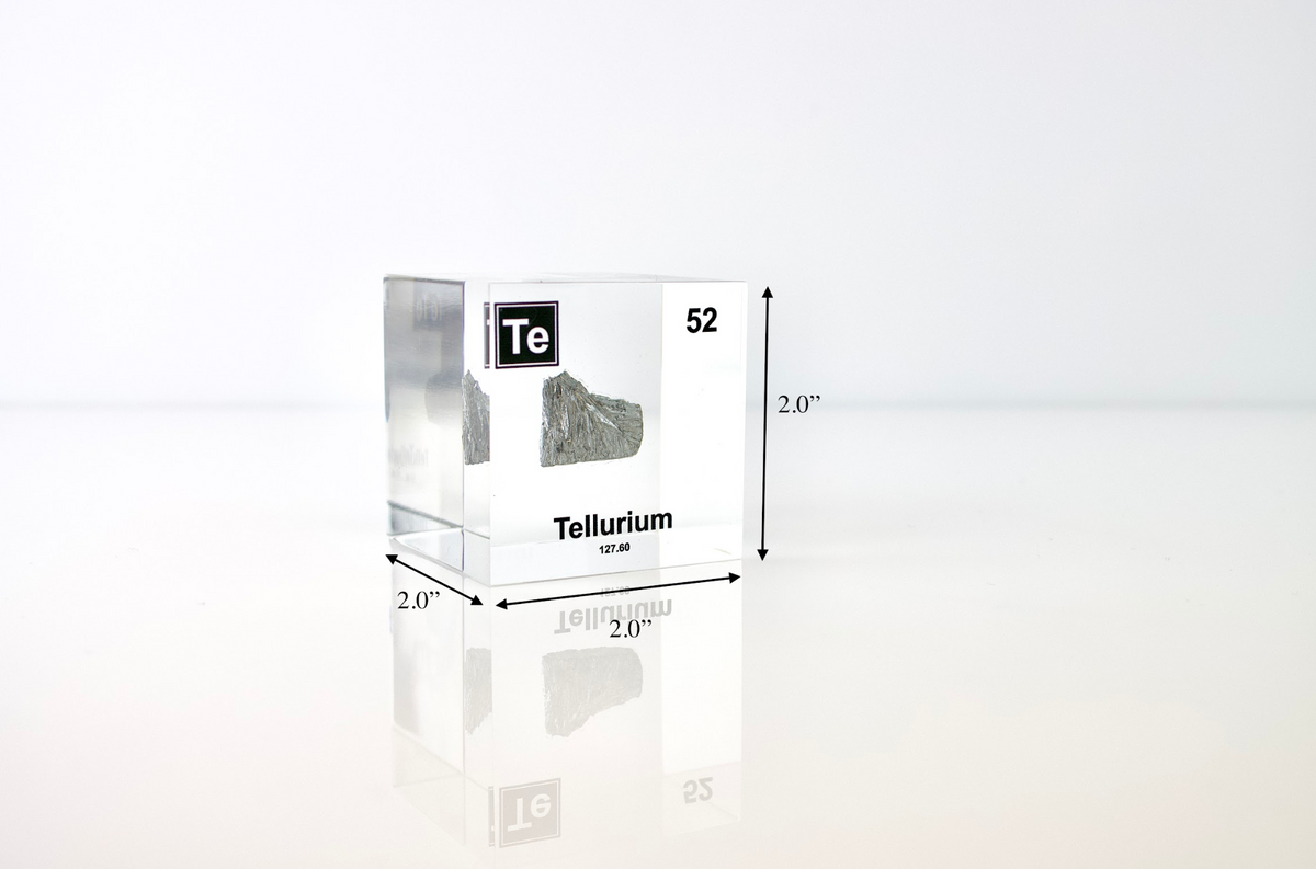 Tellurium element cube held in hand to show scale on white background, collector gift