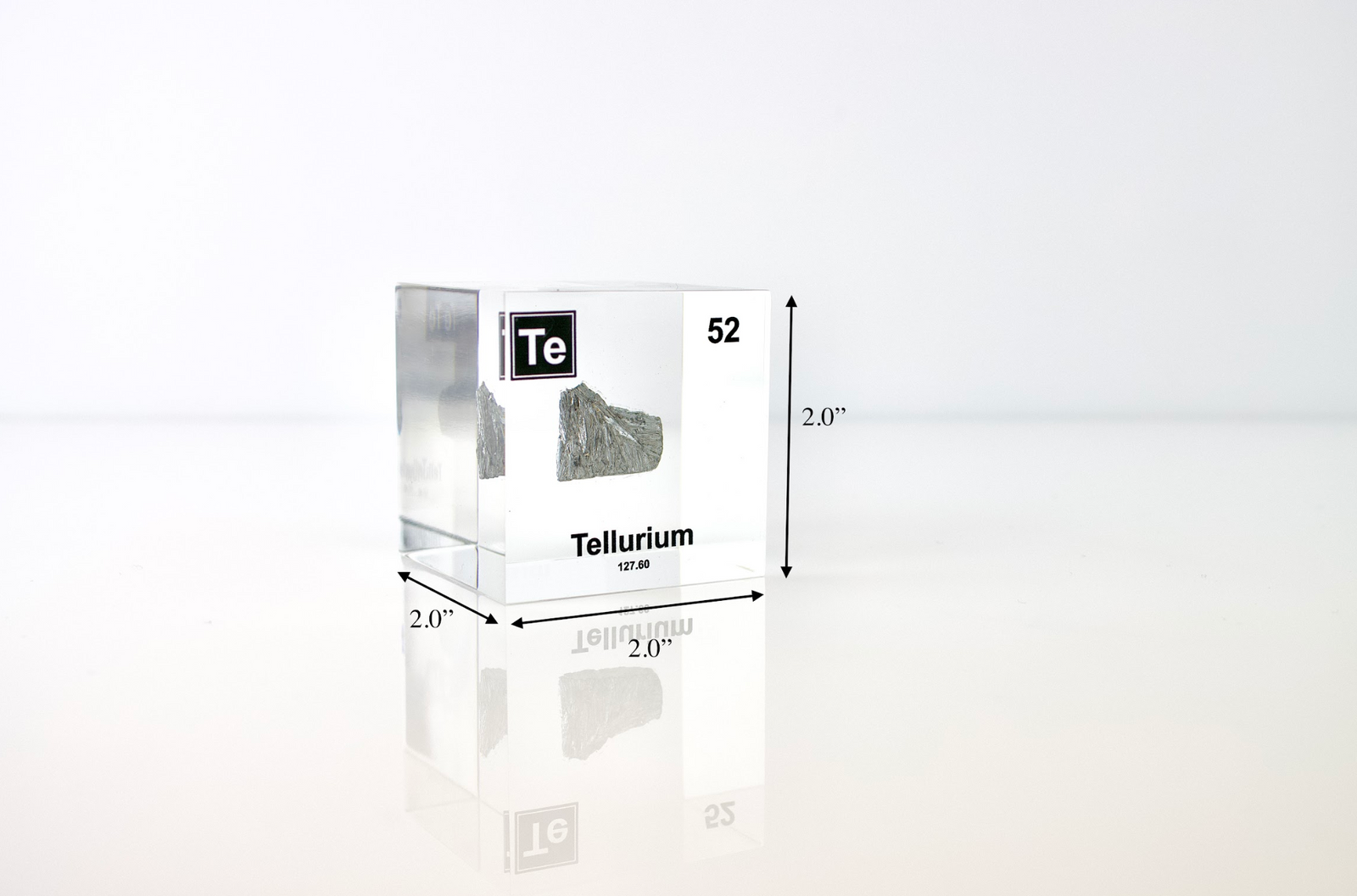 Tellurium element cube held in hand to show scale on white background, collector gift