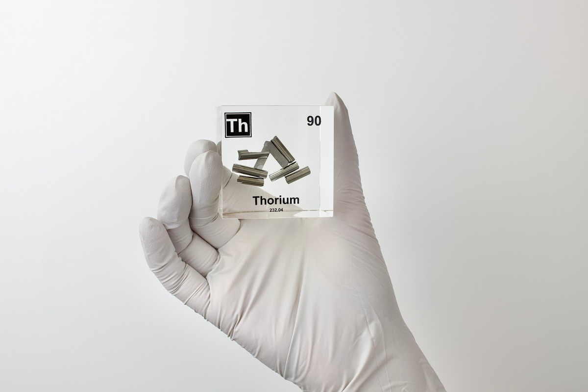 Thorium element cube held in hand showing scale on white background, collector gift