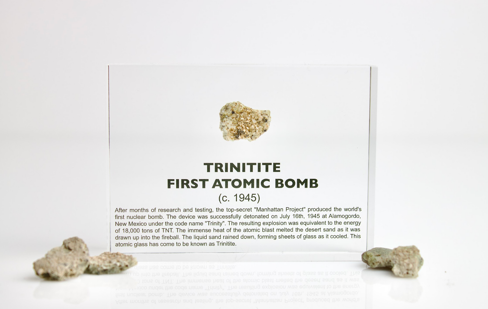 Trinitite fragment displayed beside its acrylic case on white background, unique collector gift
