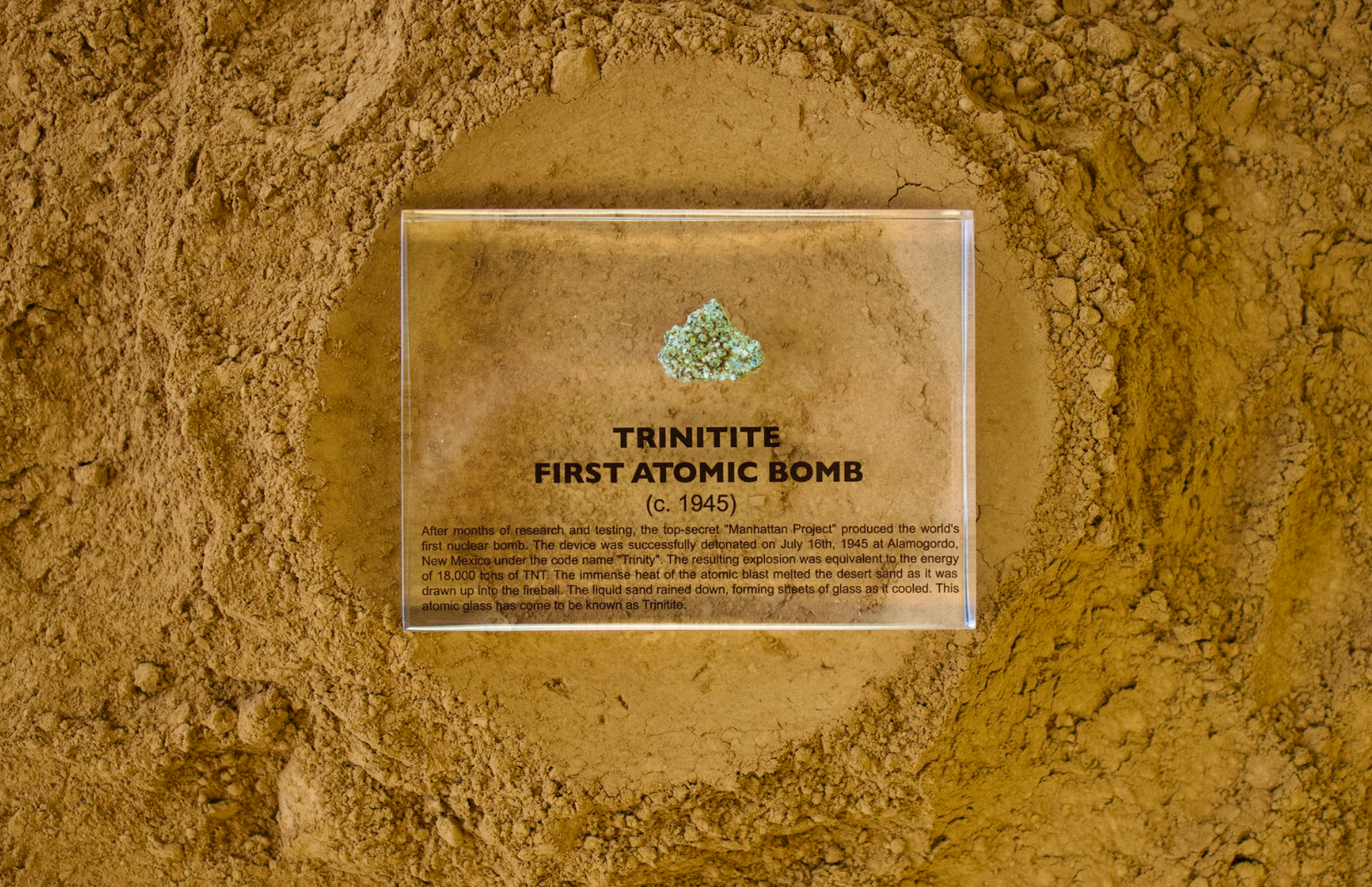 Trinitite specimen from the first atomic bomb test facing up on a textured background, collector gift