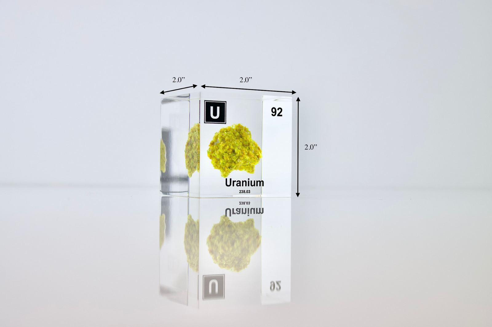 Uranium element cube with dimension measurements on white background, collector gift