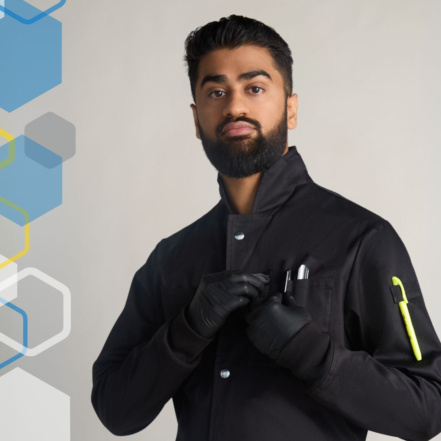 scientist wearing a medium mens howie style black lab coat with high collar that snaps closed for extra safety around chemical splashes.