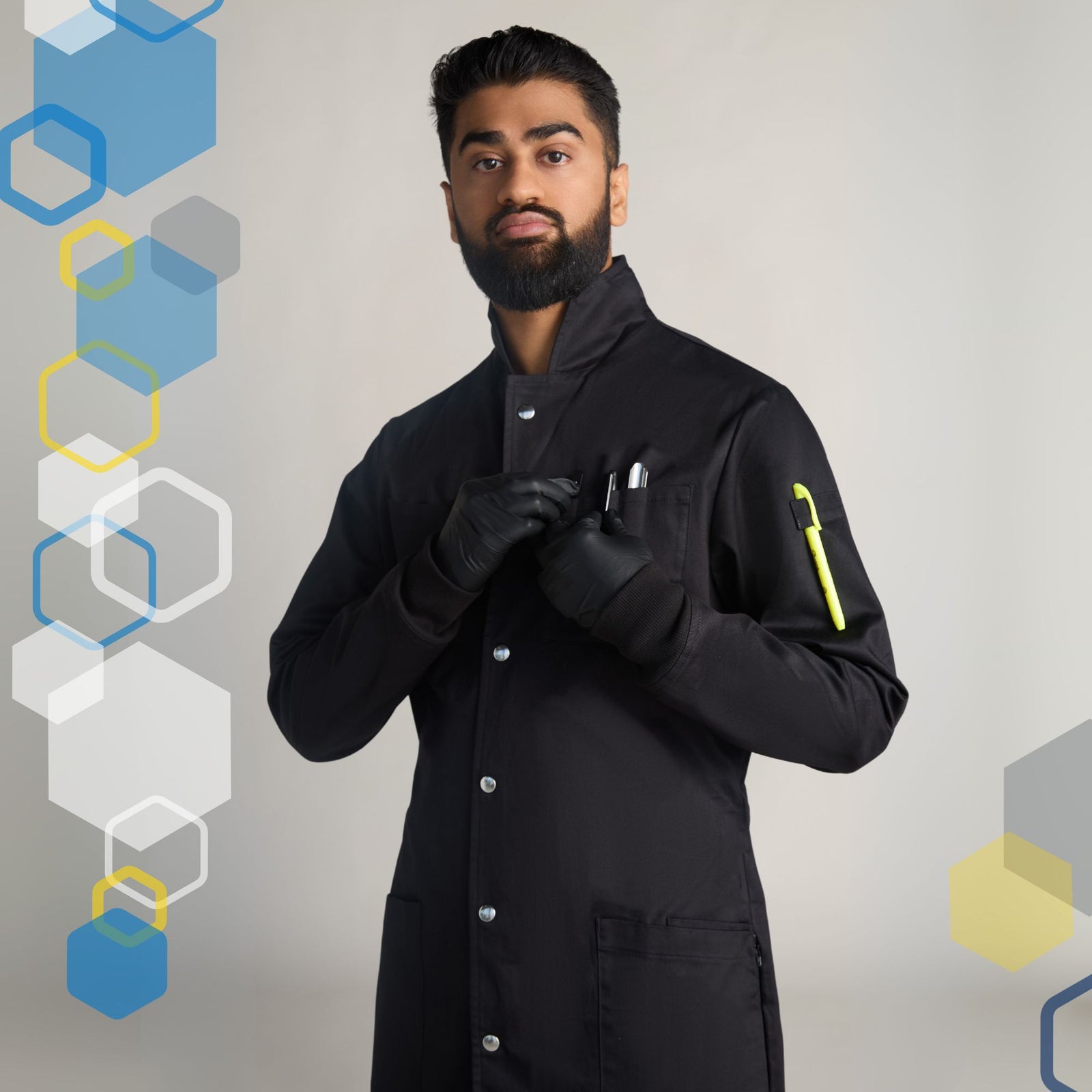 male scientist wearing a medium black howie style lab coat for college chemistry class with metal poppers and long knit cuffs on grey background