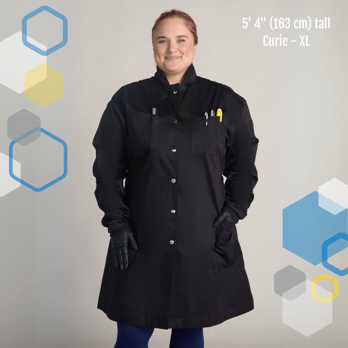 female scientist wearing women's extra large plus sized black cotton breathable lab coat with princess cut to fit wider hips. The Curie lab coat from genius lab gear