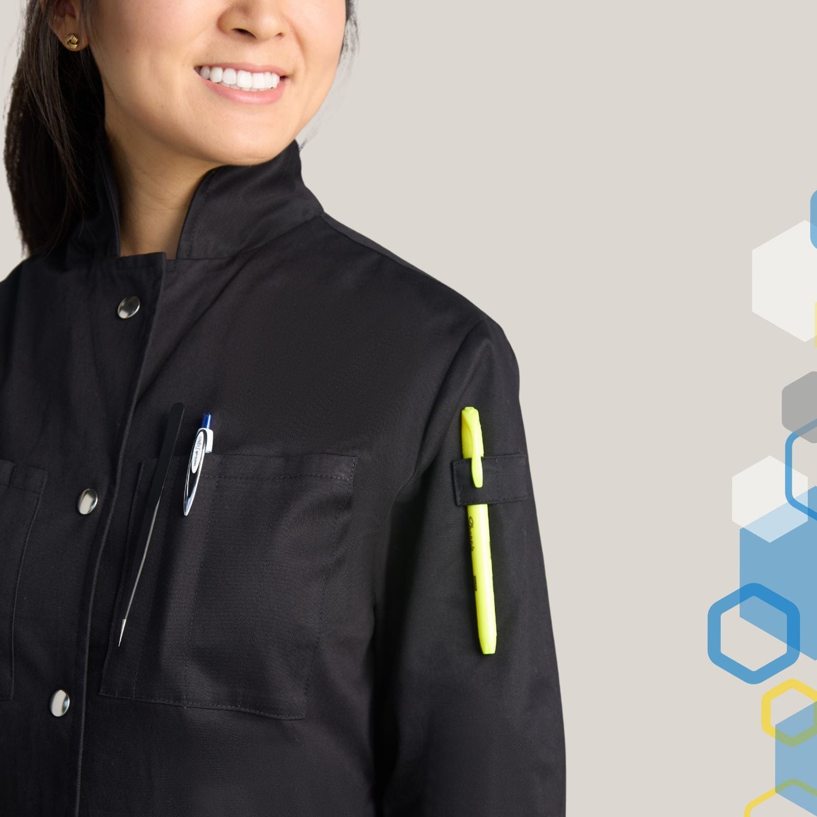 female chemist wearing a womens howie style high collar lab coat fully closed to the top button protecting her neck while wearing laboratory tweezers and utensils in upper pocket