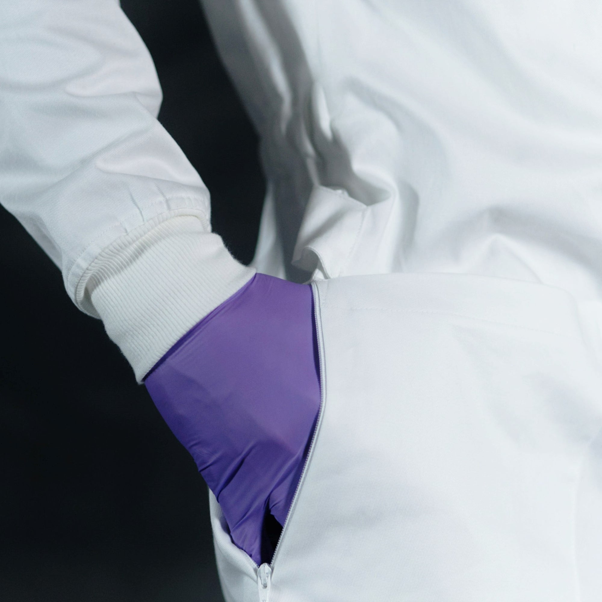 scientist hand reaching into zippered side vents of lab coat