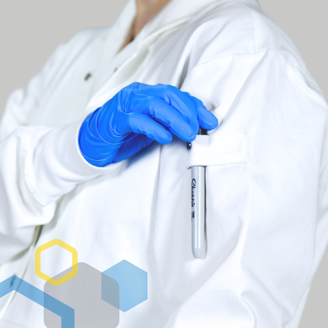 pregnant woman wearing maternity labcoat in chemistry research, reaching for a marker in a shoulder slot, wearing nitrile gloves with knit cuffs and cotton fabric