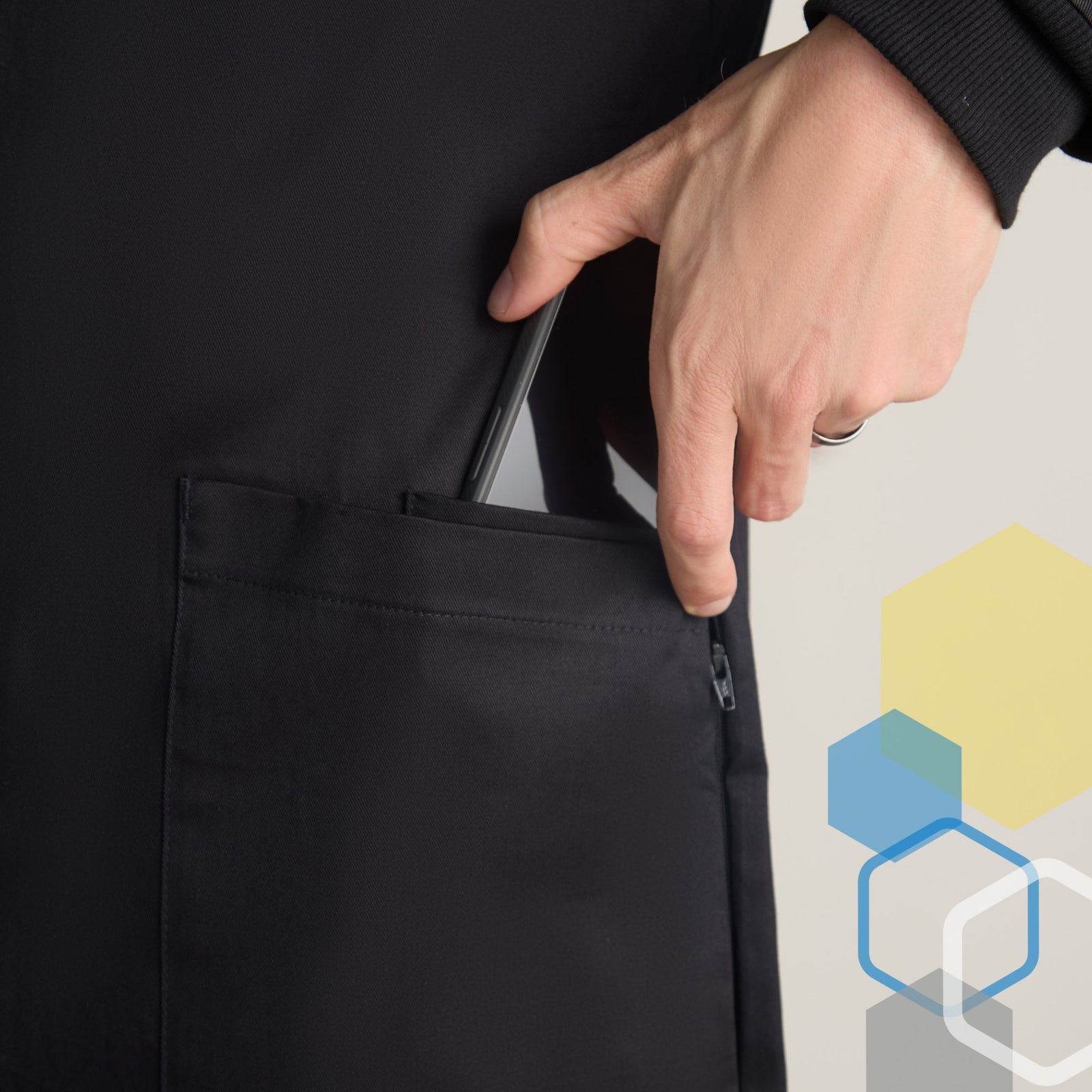 Hand pulling iphone out of hidden front phone pocket in black color lab coat for quick access