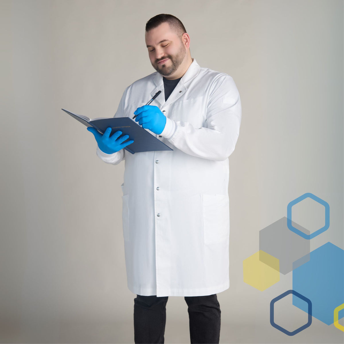 men's big and tall white cotton lab coat for 2xl, 3xl, and extra large men with broad shoulders and adjustable waist. The scientist is writing in a laboratory notebook.