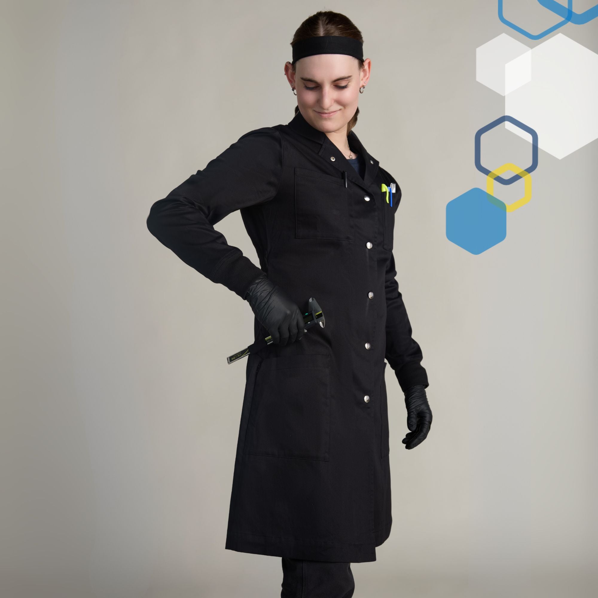 Female engineer wearing a small black 100 percent cotton scientist lab coat wearing black gloves using pockets and